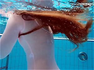 redhead Simonna demonstrating her figure underwater